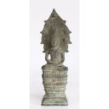 Cast metal depiction of Buddha, modelled in a seated meditating position, on a stepped loaded