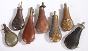 A copper and brass embossed basketwork powder flask, together with three further powder flasks and