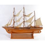 Wooden model of an unnamed sailing vessel, presented on a plinth base, 122cm high, 156cm long