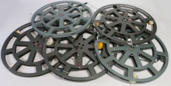 Five 35 mm film reels, four of which contain film (labelled Puss In Boots, Sherlock Holmes, VW,