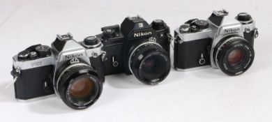 Three Nikon cameras including an Nikon EM, Nikon FE2 and a Nikon FE all with 50mm lenes (3)