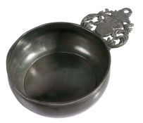A Queen Anne pewter porringer, Wigan, circa 1710 Having a bellied bowl, flat base and coronet-ear
