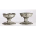 A large pair of late George III pewter cup salts, circa 1820 Each with crowned peacock device to