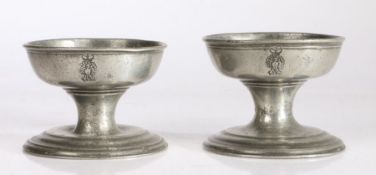 A large pair of late George III pewter cup salts, circa 1820 Each with crowned peacock device to