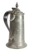 A George I pewter spire flagon, circa 1715 The straight-sided tapering drum with a high fillet,