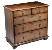 A George III walnut and cross banded chest of drawers, the rectangular top above two short and three