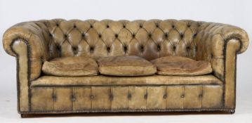 A leather three seater chesterfield settee, the green leather buttoned back and arms above three