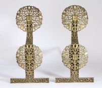 A pair of Arts and Crafts brass and cast iron andirons, each iron with two pierced foliate and