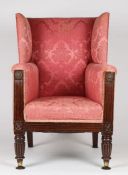 A Regency mahogany and upholstered wing arm chair, upholstered in a red floral fabric, above