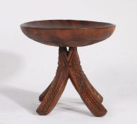 An African carved tribal Igbo stool, Nigeria, circa 1920, the chip carved dished seat raised on