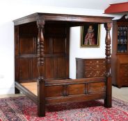 An oak tester bed, the tester with sixteen panels above a headboard formed from nine panels, the