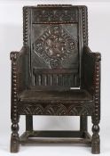 An 18th Century and later oak armchair, the scroll carved cresting rail above a stylised foliate