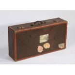 An oversized French suitcase, in the Louis Vuitton manner, with brass corner mounts and plaque to