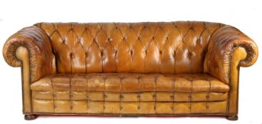 A Victorian leather upholstered chesterfield sofa, the button back and scroll arms above the