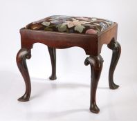 A George III mahogany stool, the drop in seat with foliate decoration above an undulating frieze and