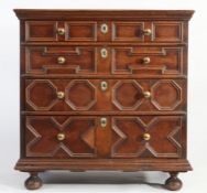 A Jacobean style chest of four long drawers, with geometric moulded drawer fronts, raised on bun
