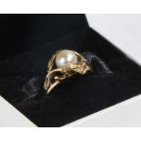 14 carat gold and pearl ring, the head set with a central spherical pearl and a leaf design to the