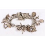 Silver and white metal charm bracelet, containing many charms to include a hedgehog, Isle Of Man