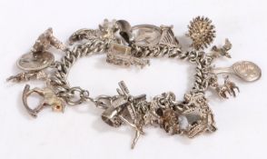 Silver and white metal charm bracelet, containing many charms to include a hedgehog, Isle Of Man
