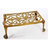 A good Victorian brass trivet, the pierced scroll top decorated with a pair of birds raised on