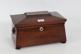 A Victorian rosewood sarcophagus tea caddy, with a gadrooned beaded top opening to reveal a fitted