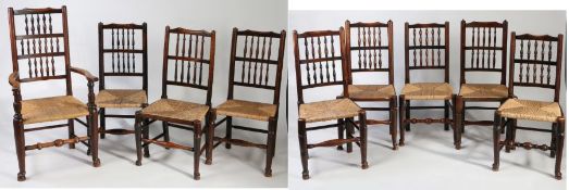 Nine Lancashire oak spindle back dining chairs, with woven rush seats, comprising one carver and