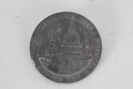 Lead plaque depicting St Paul's Cathedral on fire, with the words "Bombed Burned But Unbeaten London