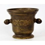 A 19th century bronze mortar the body decorated with a floral motif and with a pair of handles