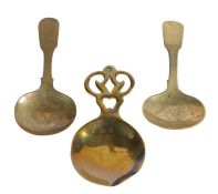Three 19th century brass caddy spoons, English Two of similar design, engraved, and with fiddle-