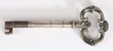 Early 19th Century silver sheathed key, the shell and scroll pierced terminal above a reeded stem