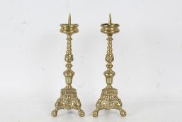 A Pair of brass pricket candlesticks with a turned and twisted steam above a tripod case with ball