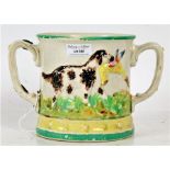 A Large Staffordshire "Lizard" mug, with twin handles above a body decorated with dogs and