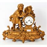 French gilt metal mantle clock, decorated with a young child reading a book, the white dial with