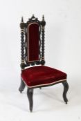 A Victorian ebonised and parcel gilt chair, with turned ebonised supports above a red upholstered