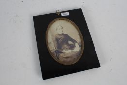 A Victorian ebonised photo frame, set with a brass oval insert and acorn to the top, 27cm by 22cm