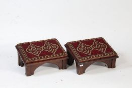 A Pair of Victorian Gothic oak footstools/Church Kneelers, the angled top set with needle work