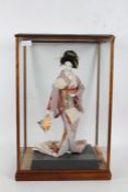 Japanese Geisha doll, 20th century, housed in a wooden and glazed case, 55cm tall, 36cm wide, 30cm