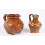 Two 17th century Dutch slipware pieces of pottery To include a jug with text to the bulbous body,