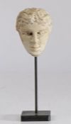 A carved marble bust, possibly Roman With curled hair above sunken eyes and narrow chin, raised on a