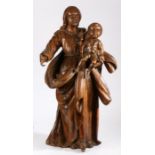An 18th century walnut figural carving, Madonna and Child The Virgin Mary wearing flowing robes,