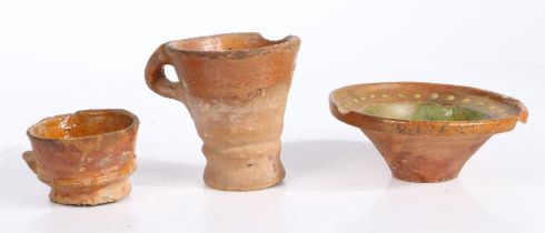 Three pieces of 18th century Dutch pottery To include a drinking cup, a tall cup and a bowl with
