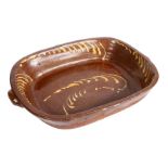 A very large 19th century slipware roasting dish Of rectangular form with a pair of handles, the