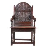 A rare Charles II oak panel-back open armchair, Lancashire, circa 1670 The back panel carved with