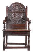 A rare Charles II oak panel-back open armchair, Lancashire, circa 1670 The back panel carved with