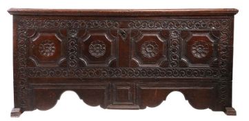 A 17th century boarded oak coffer, German, Having a one piece lid, the front carved with four