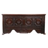 A 17th century boarded oak coffer, German, Having a one piece lid, the front carved with four