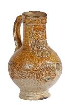 A 17th century salt glazed Bellarmine With a bearded mask above three flower head panels to the