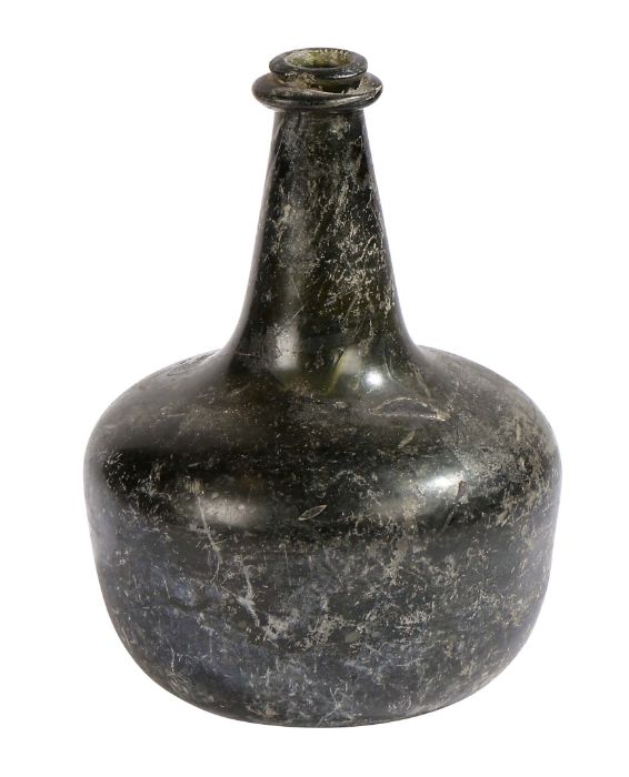 An early 18th century glass onion bottle, English, 1700-1720 Dark blue glass, inverted pontil mark