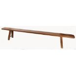 A Victorian pitch pine bench, circa 1840 Having a deep and one-piece rounded rectangular top, with