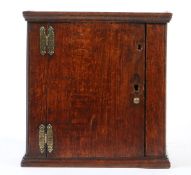 A small oak boarded mural cupboard, English, circa 1700 Having a simple cornice, plain door and